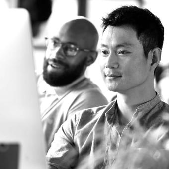 Two coworkers looking at a monitor